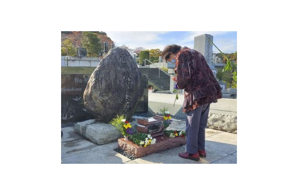 「原爆被害者の墓」に手を合わせる女性＝30日午後、東京都八王子市