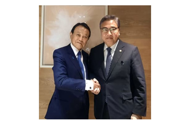 3日、ソウルで握手を交わす自民党の麻生副総裁（左）と韓国の朴振外相（韓国外務省提供、聯合＝共同）