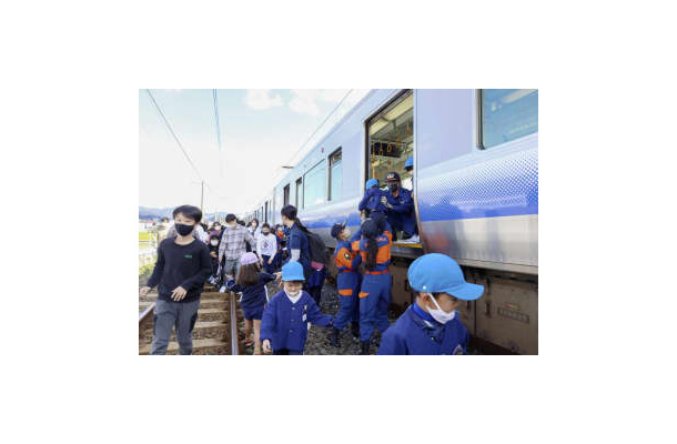 津波避難訓練で、緊急停止した列車から避難する園児ら＝5日午前、和歌山県広川町