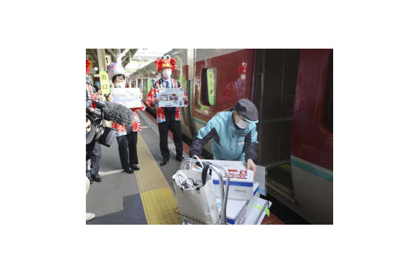 大阪での即日販売のため、水揚げされたズワイガニを特急列車に運び込む関係者＝19日、JR米子駅