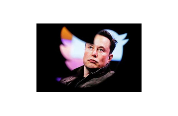 ツイッターのロゴ越しに写るイーロン・マスク氏（ロイター＝共同）