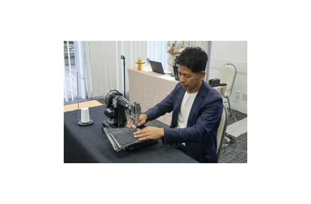 新商品のミシンで実演するアックスヤマザキの山崎一史社長＝10月、大阪市