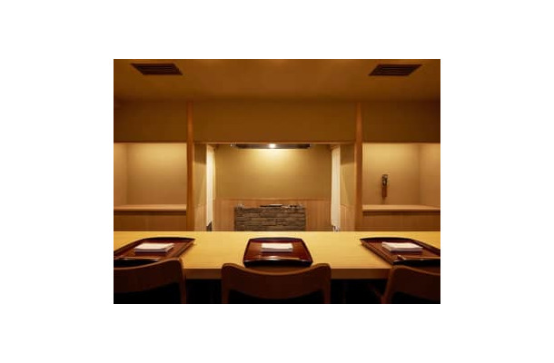 京都を拠点に、和食店を多く造る建築家が手掛けた内装。数寄屋造りで座り心地の良いイスは「アルフレックス」。カウンター正面の焼き台で鴨が焼かれていく