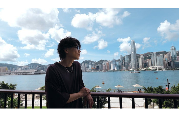 ビクトリア・ハーバー越しに香港を象徴する高層ビル群を望む佐藤健／提供画像