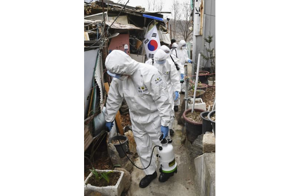 3日、ソウル市の低所得者層が住む地域を消毒する作業員ら（共同）