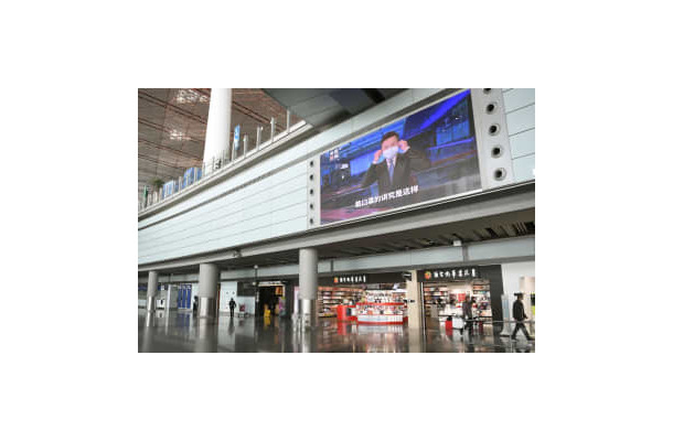 閑散とする北京首都国際空港の到着ロビー。大型モニターにはマスク着用を呼び掛ける映像が流れていた＝12日（共同）