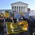 昨年12月、米連邦最高裁前でプラカードや横断幕を掲げる人工中絶擁護、反対両派の人たち＝米ワシントン（共同）