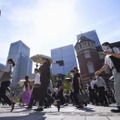 強い日差しの中、日傘を差して歩く人たち＝30日午前、JR東京駅前