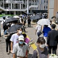 安倍元首相が銃撃された現場付近に設置された献花台に並ぶ人たち＝9日午前10時36分、奈良市