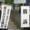 判決後に「勝訴」などと書かれた垂れ幕を掲げる原告側弁護士＝7日午前、長崎地裁前