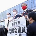 名古屋高裁金沢支部前で「違憲状態」と書かれた紙を手にする原告側の弁護士ら＝10日午後